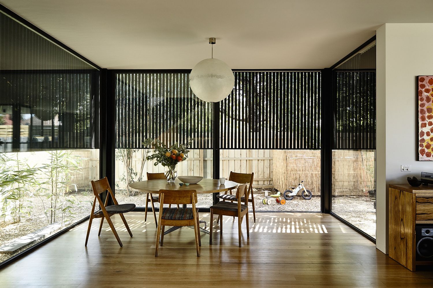 New dining area with glass walls overlooks the rear yard