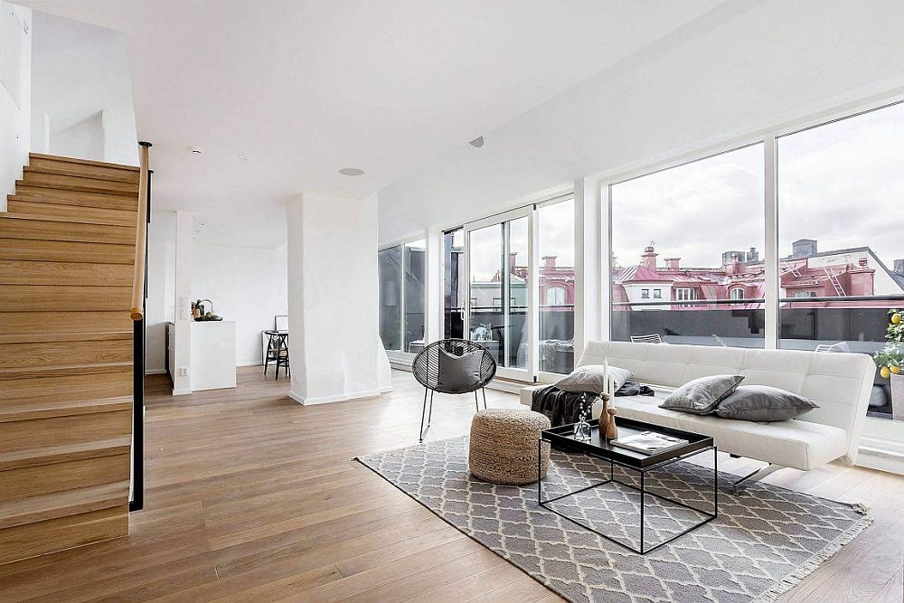 Open living area of the Scandinavian style apartment connected to the lovely balcony outside