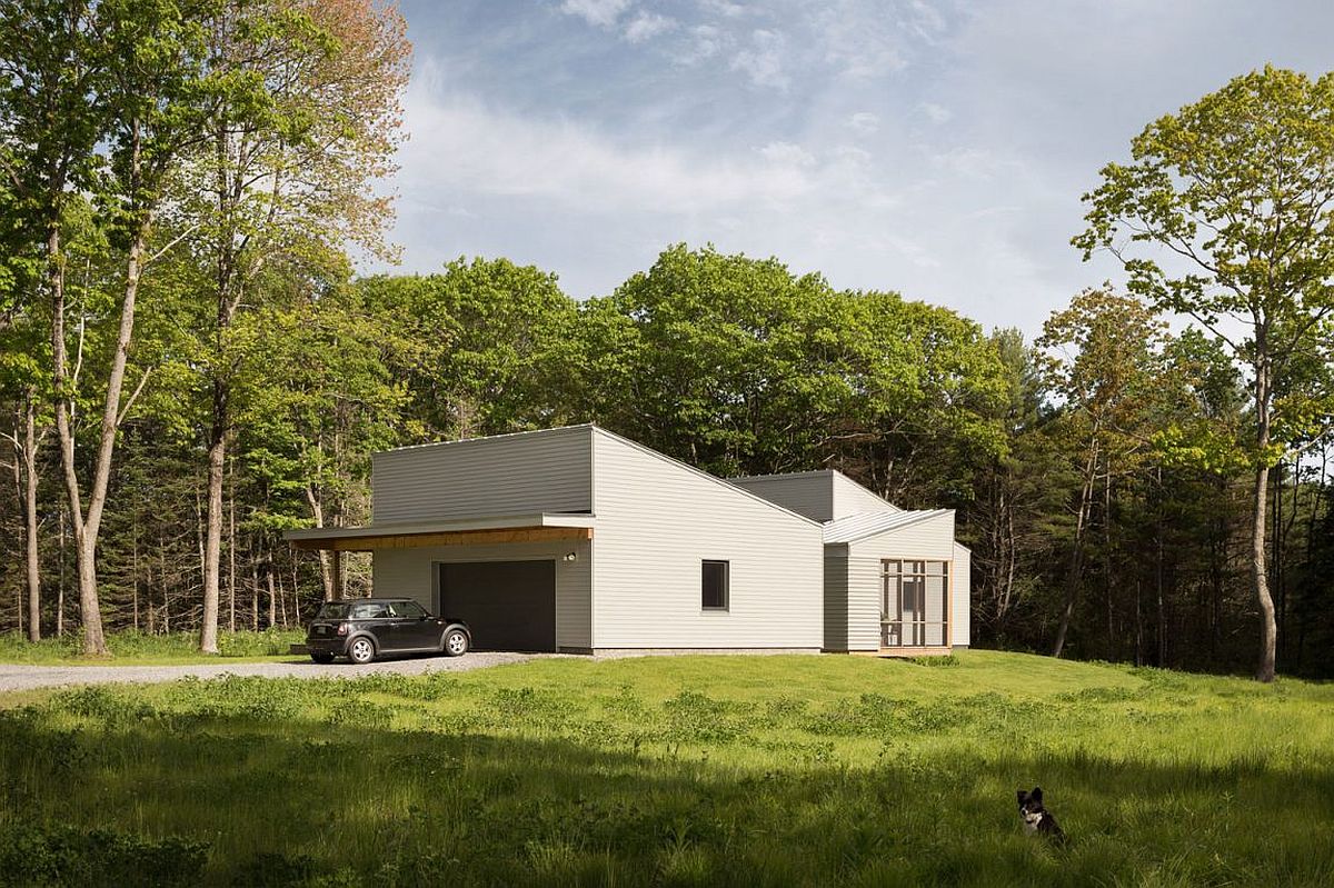 Pine forest with tall trees surrounds the Southern Maine home