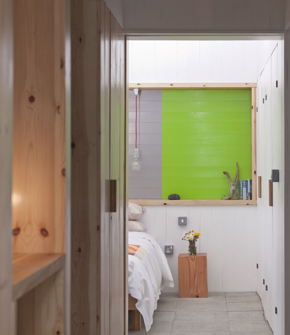 Serene modern bedroom in white with a pop of green