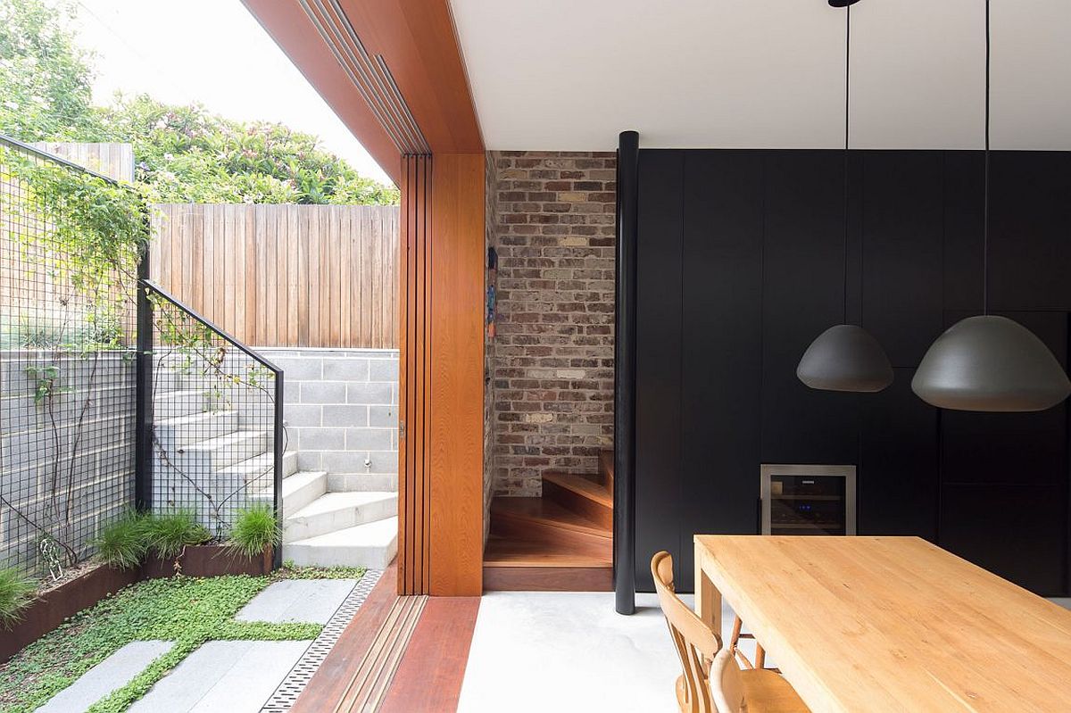 Sliding glass doors connect the green space and rear yard with the living and dining areas