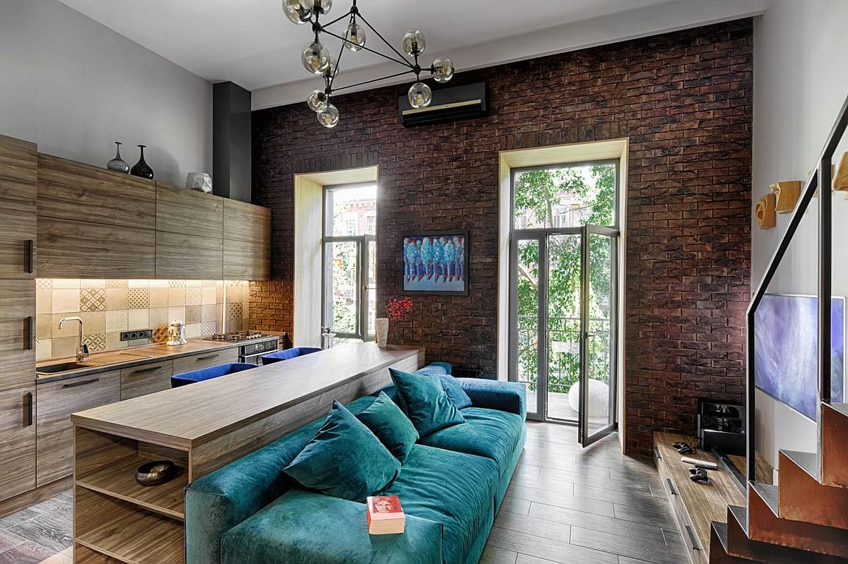 Small apartment living room with large windows, beautiful cobalt blue couch and custom wooden cabinetry