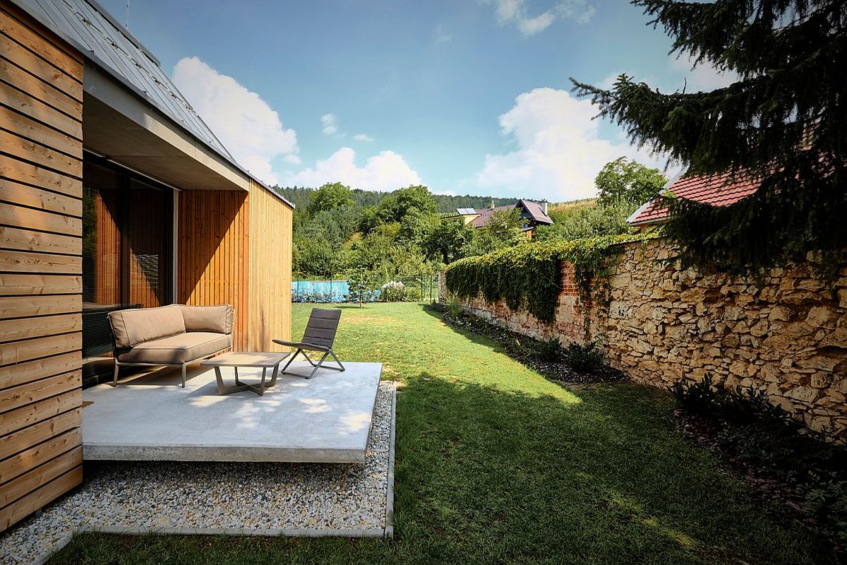 Small concrete deck offers outdoor living space that flows into the spacious yard