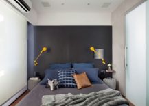 Small-contemporary-bedroom-with-gray-accent-wall-and-bright-yellow-sconce-lighting-217x155