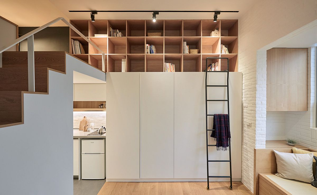 Track lighting illuminates the open shelves above the wardrobe