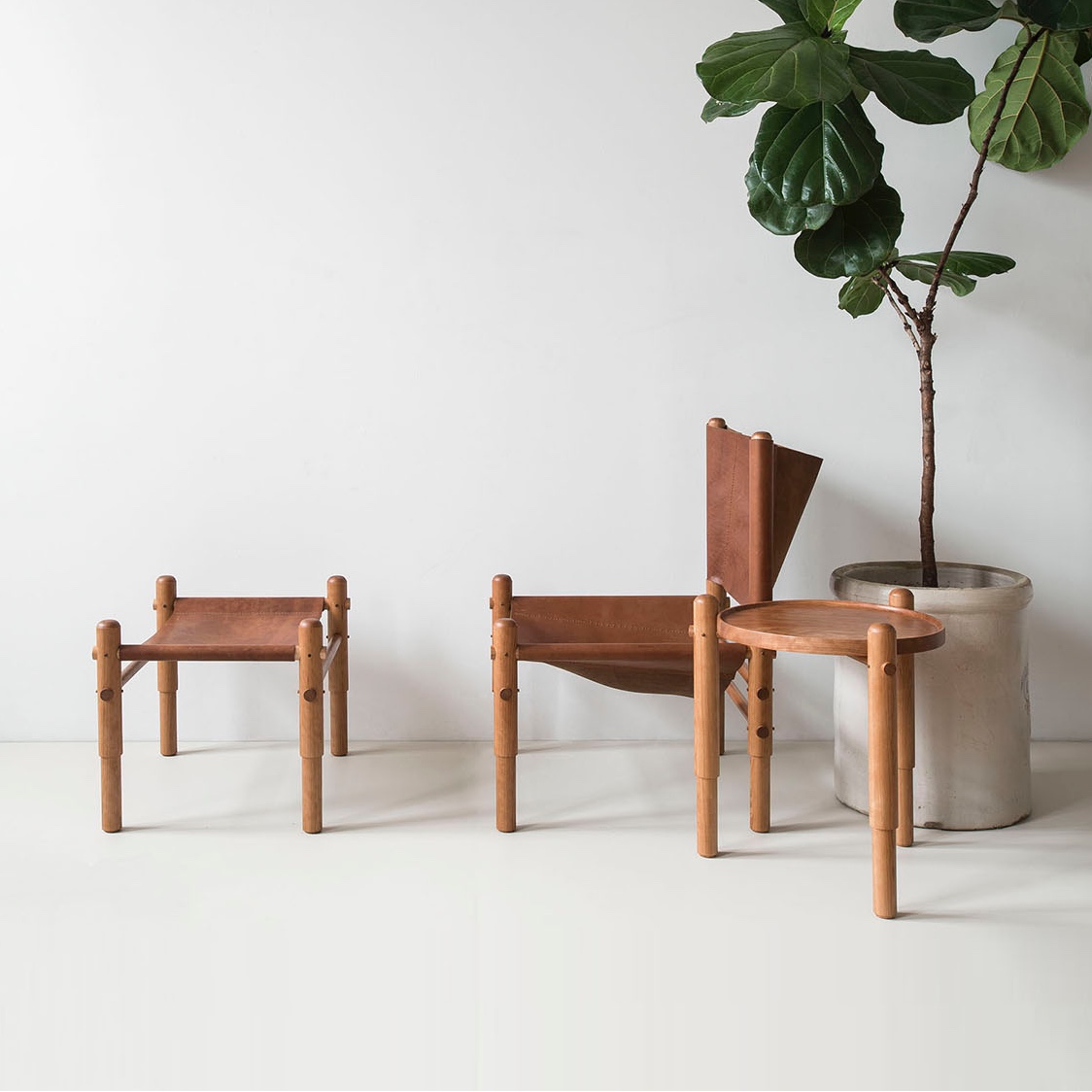 L ro R: Sling Chair, Sling Ottoman and Spool Side Table. Wood and leather. Clean, simple and unique.