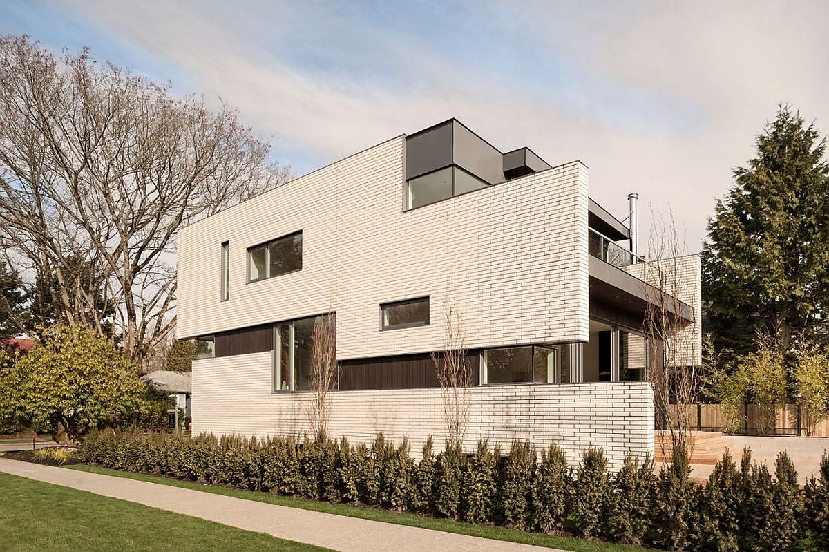 A touch of gray, glass windows and wood bring contrast to the white facade