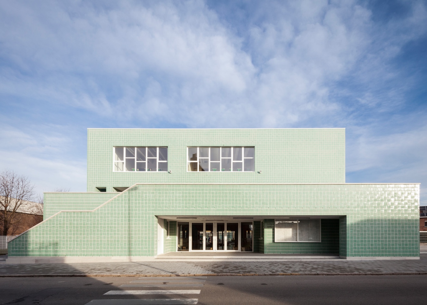 Fresh mint-green glazed bricks adorning a school facade.