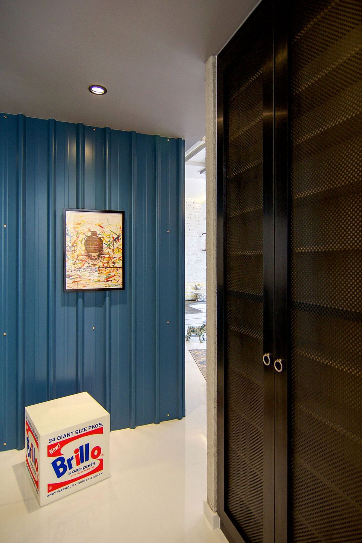 Blue metallic claddin on the wall welcomes you to the colorful home in Singapore