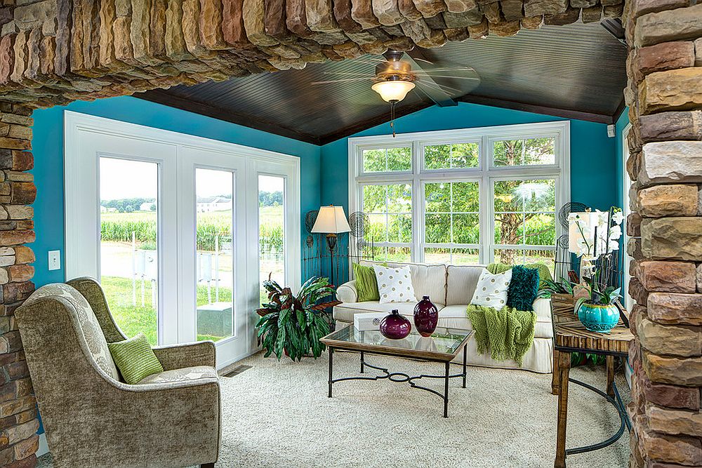 Cheerful tropical sunroom with dark ceiling and walls in bright blue [Design: Schumacher Homes]