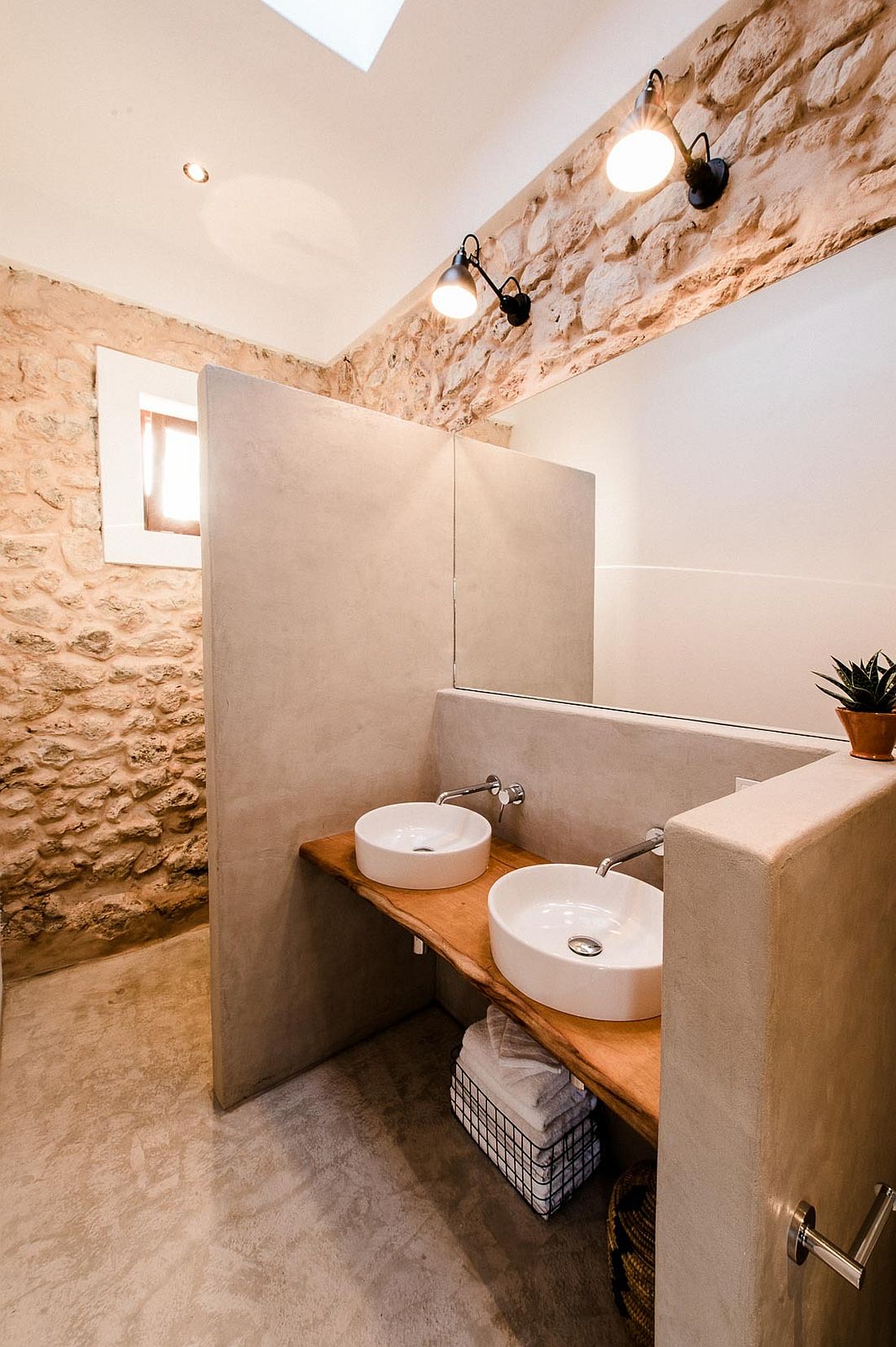 Classic stone walls coupled with modern aesthetics and live edge vanity in the bathroom