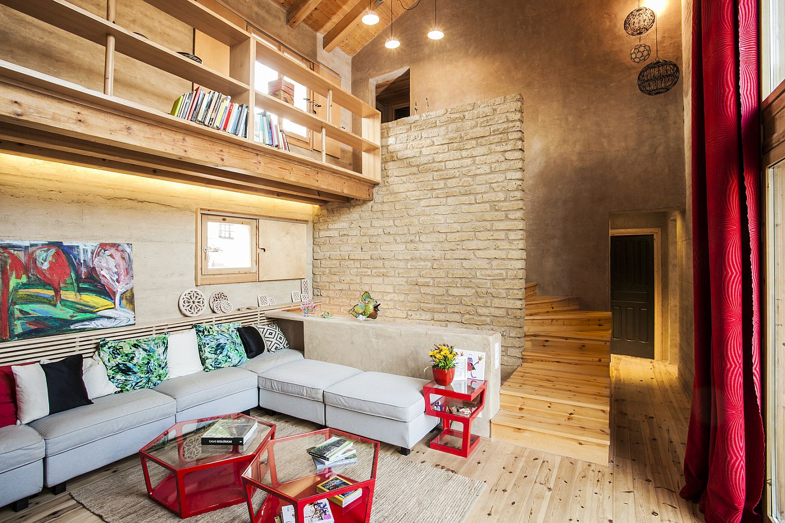 Coffee tables in red and lighting bring brightness to the living area