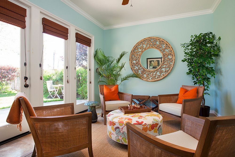 Colorful tropical sunroom with pops of orange and a gentle blue backdrop [From: Deborah Gordon Designs]