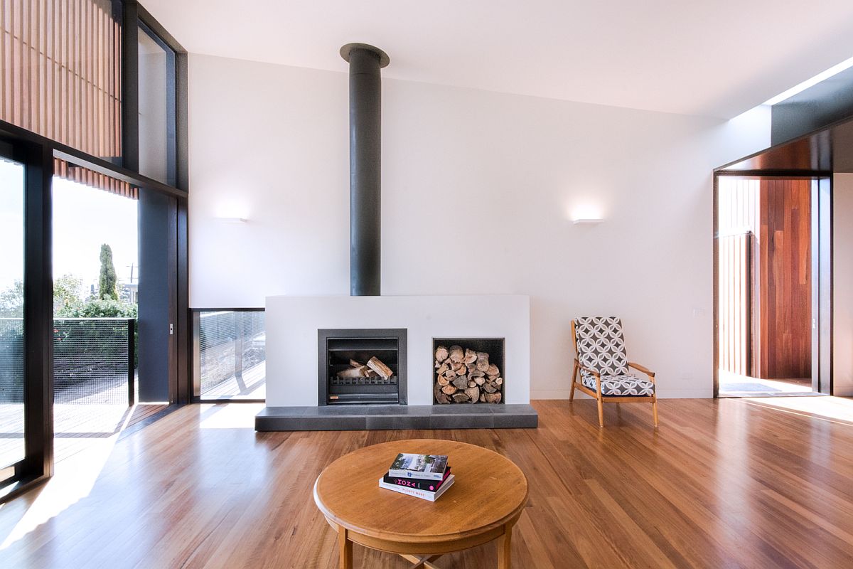 Fireplace with stacked wood next to it in th open living area