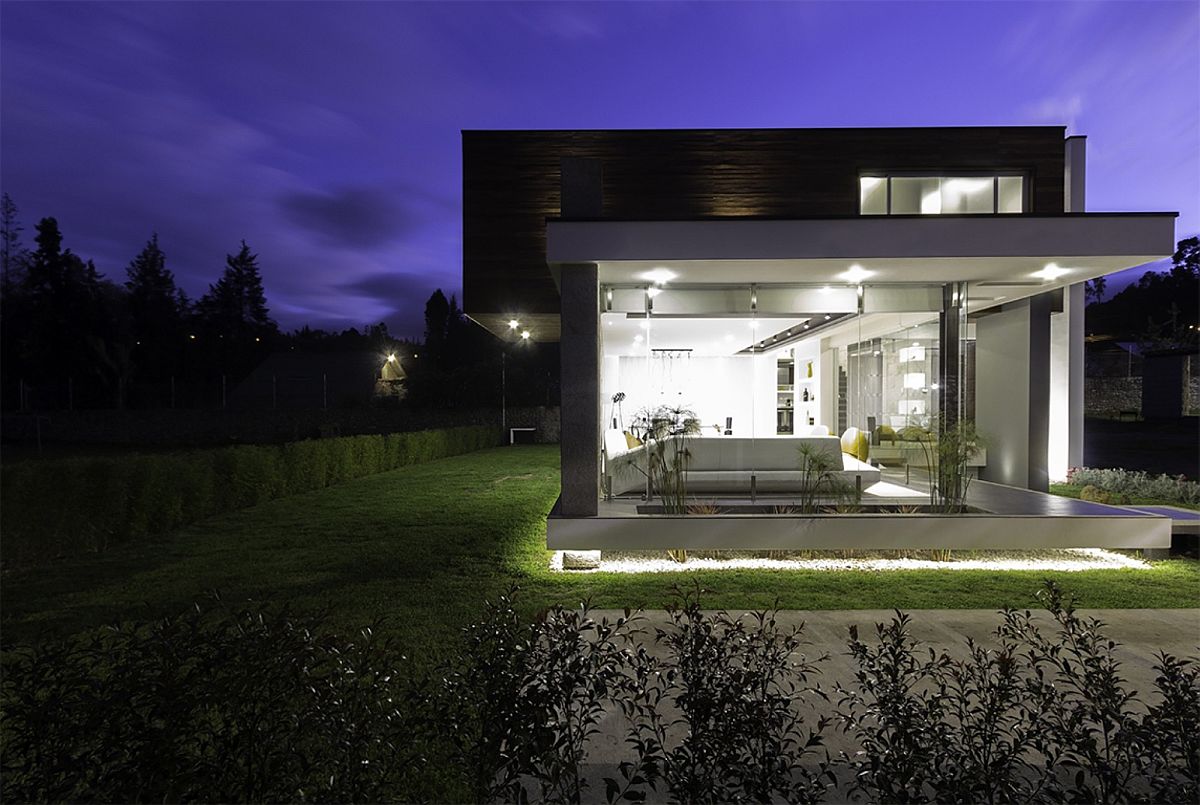 Floor-to-ceiling glass walls connect the living area with the garden