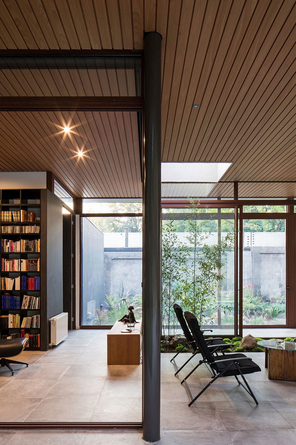 Gorgeous use of framed glass walls brings the greenery inside