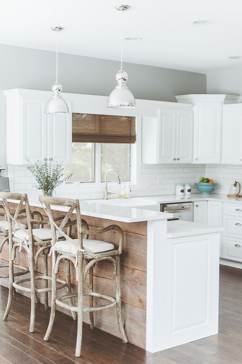 Kitchen island covered in reclaimed wood brings contrast to the polished kitchen