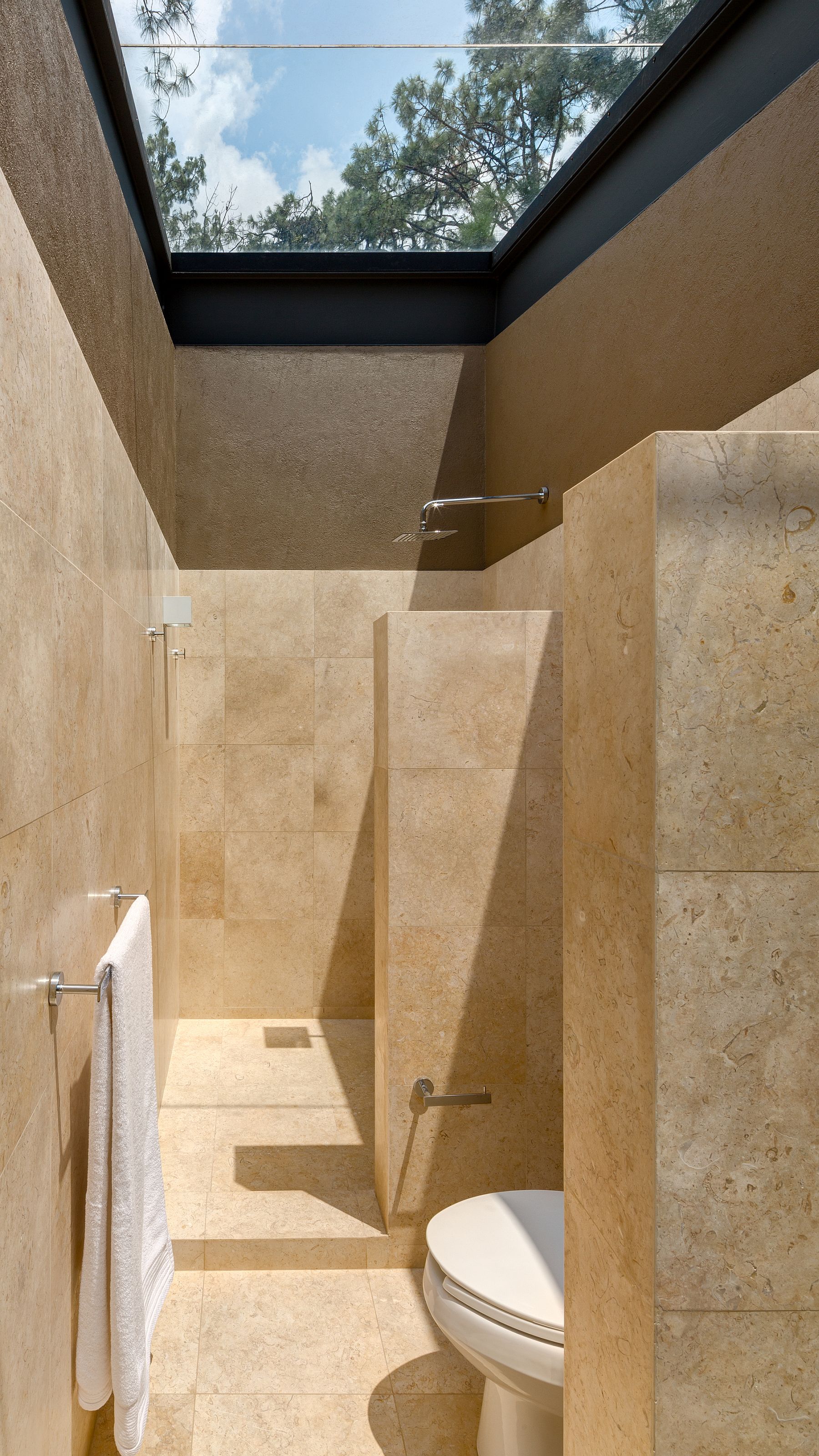 Master bathroom with glass ceiling brings the natural canopy indoors