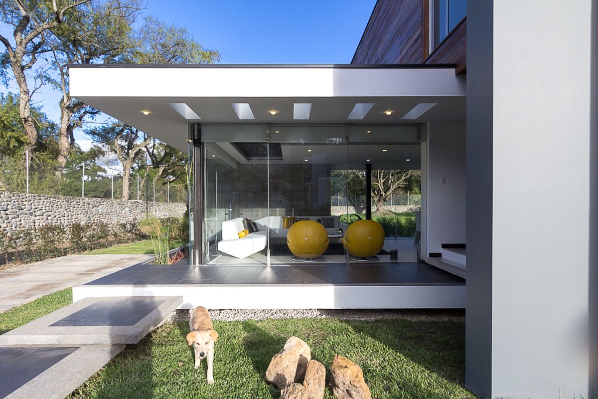 Sitting area with glass walls extends outside from the central living zone