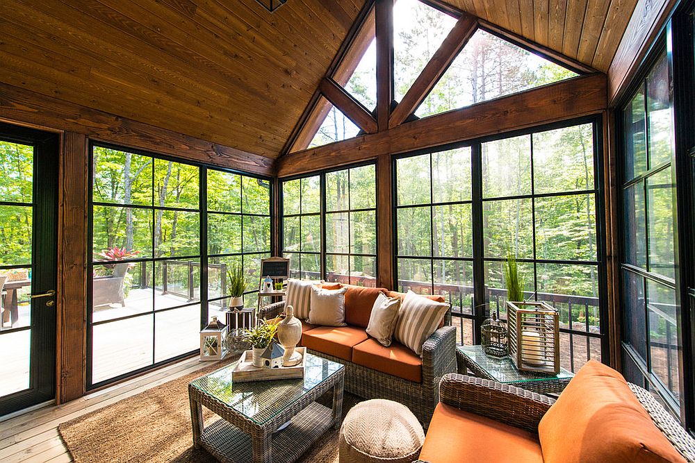 Smart sunroom with breezy decor is connected with the deck outside [Design: Linwood Custom Homes]