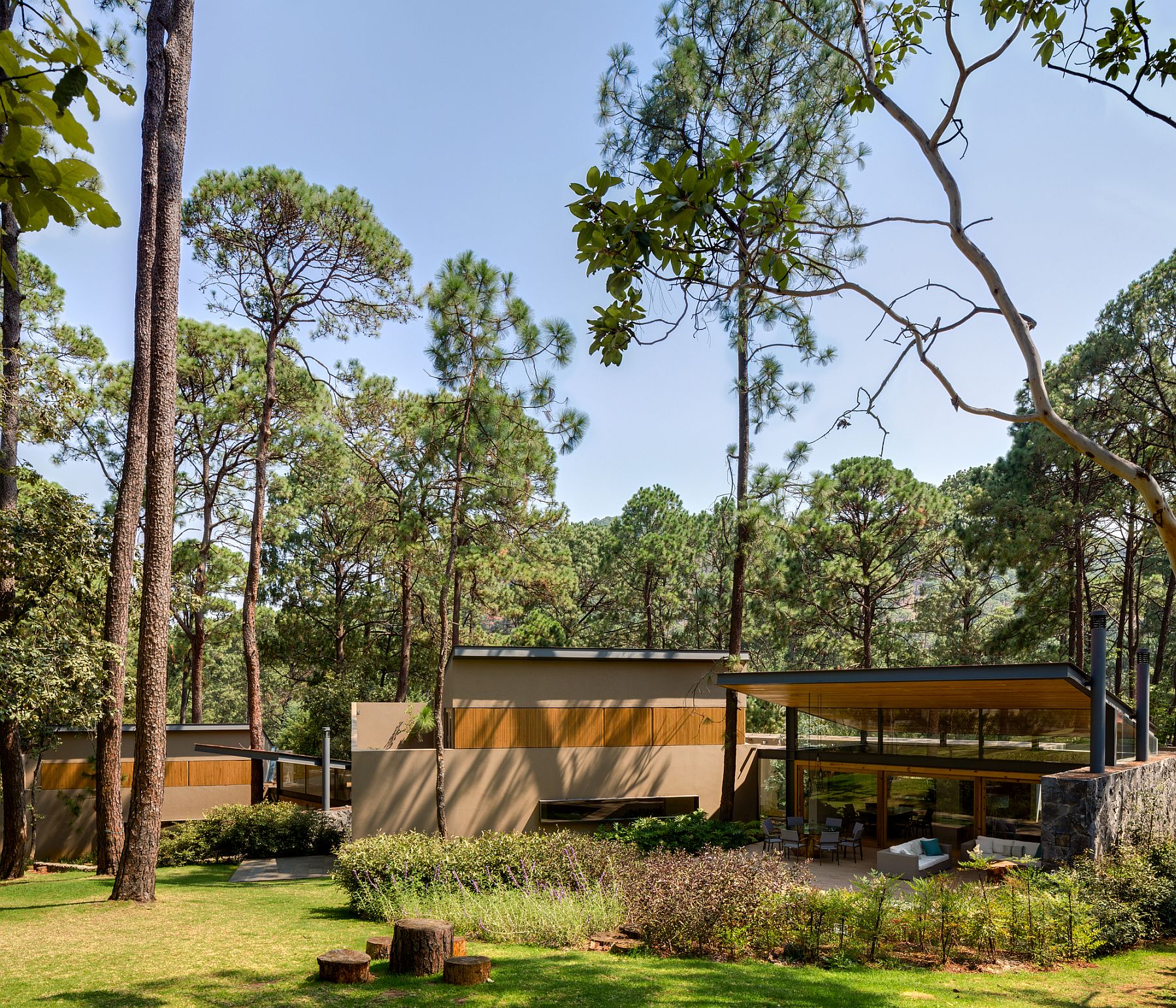 Three individual structures make up the larger house nestled in forest