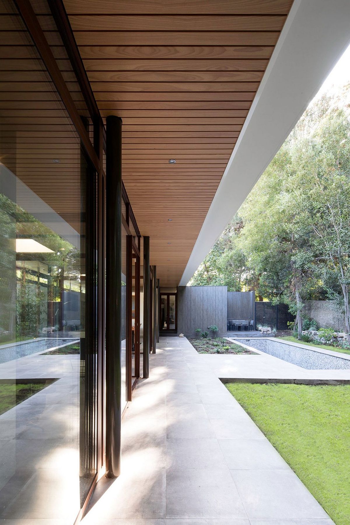 Wood ceiling and stone floor define the beautiful residence with cool indoor-outdoor interplay