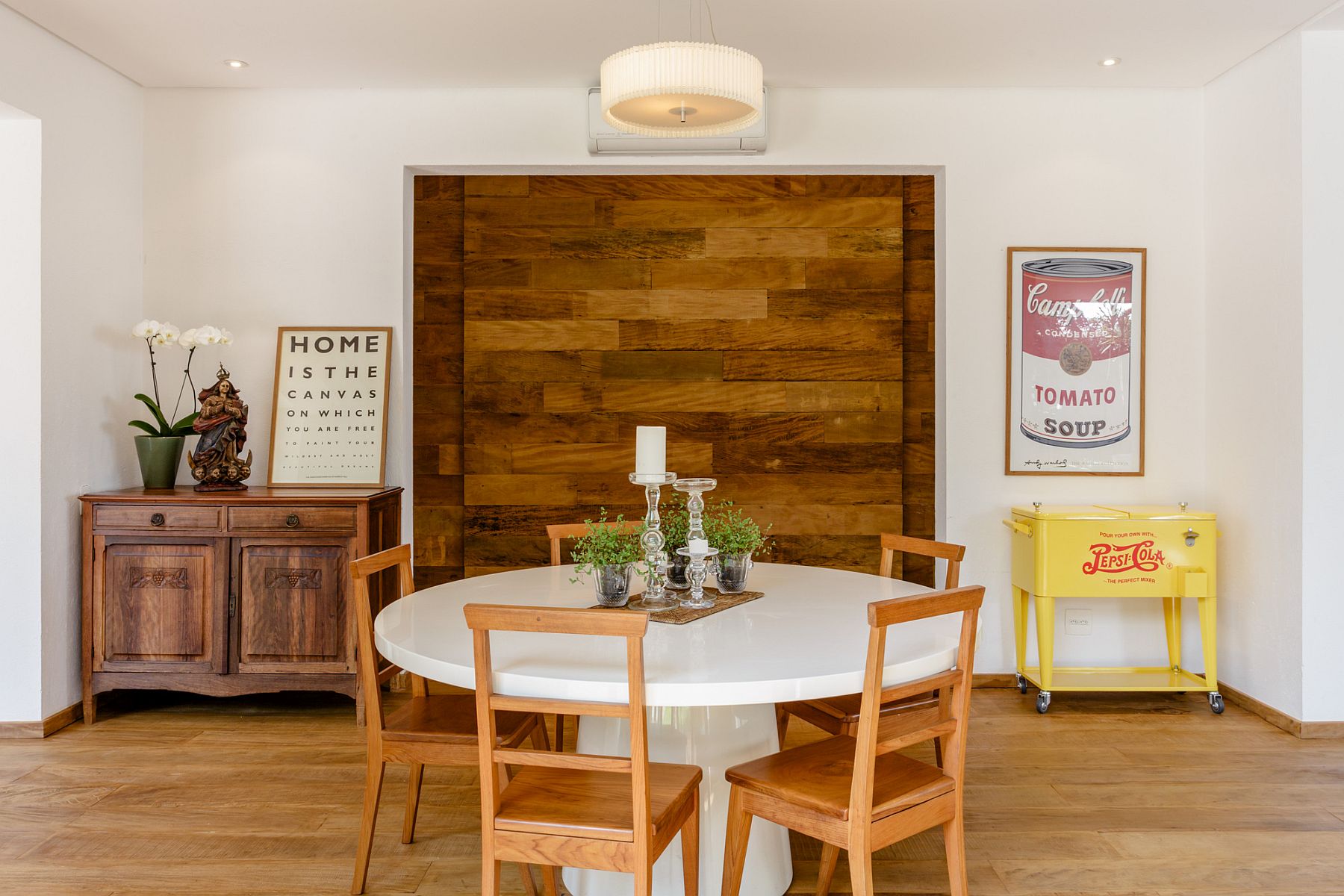 Wooden accent feture in the backdrop brings warmth and contrast to the dining room in white