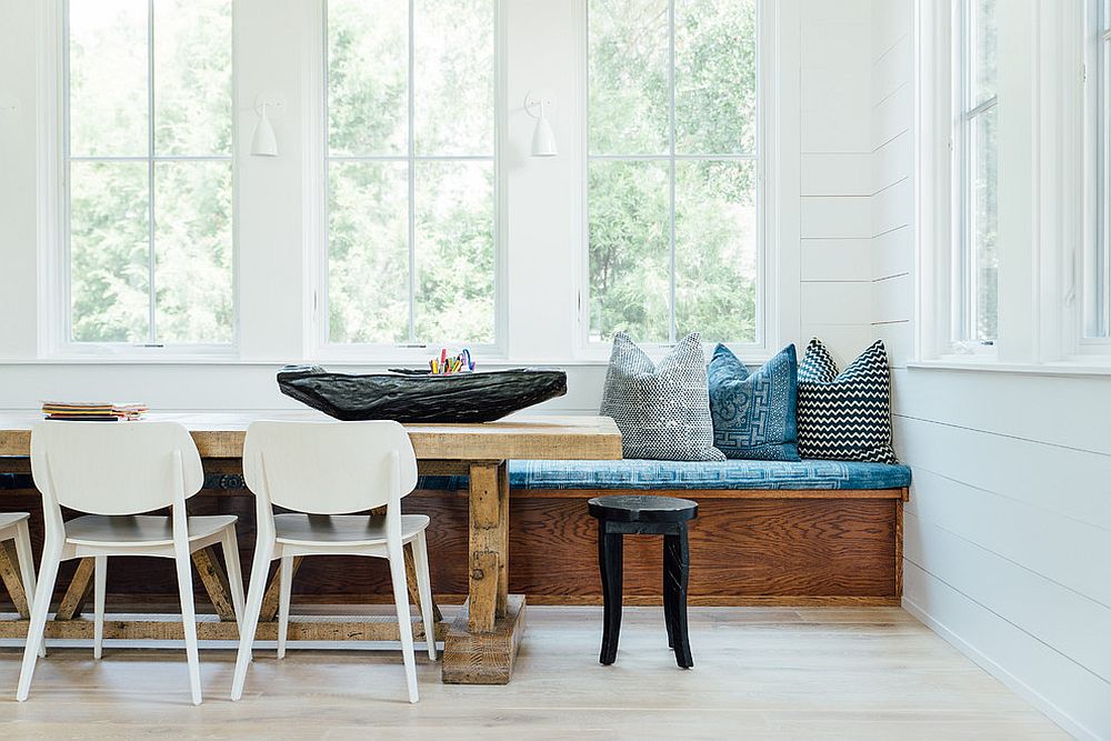 Wooden dining table, banquette and chairs in white combined seamlessly [Design: Cortney Bishop Design]