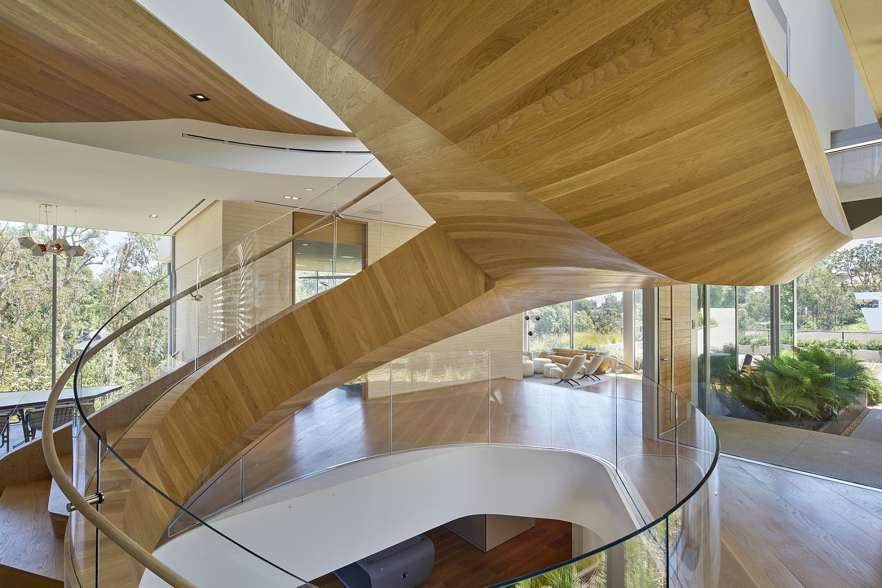 Amazing curvy staircase delineates spaces and adds extravagance to the interior