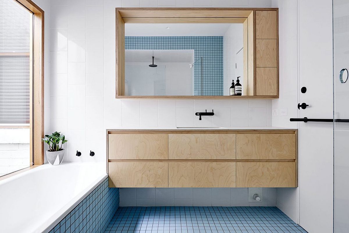 Beautiful blue tiles energize the contemporary bathroom in white