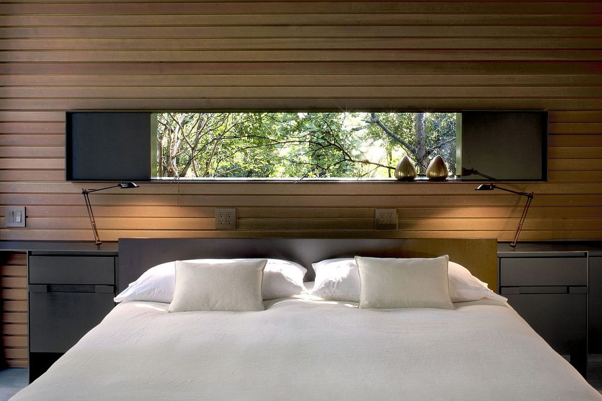 Bedroom with a window above the headboard that offers a view of the outdoors