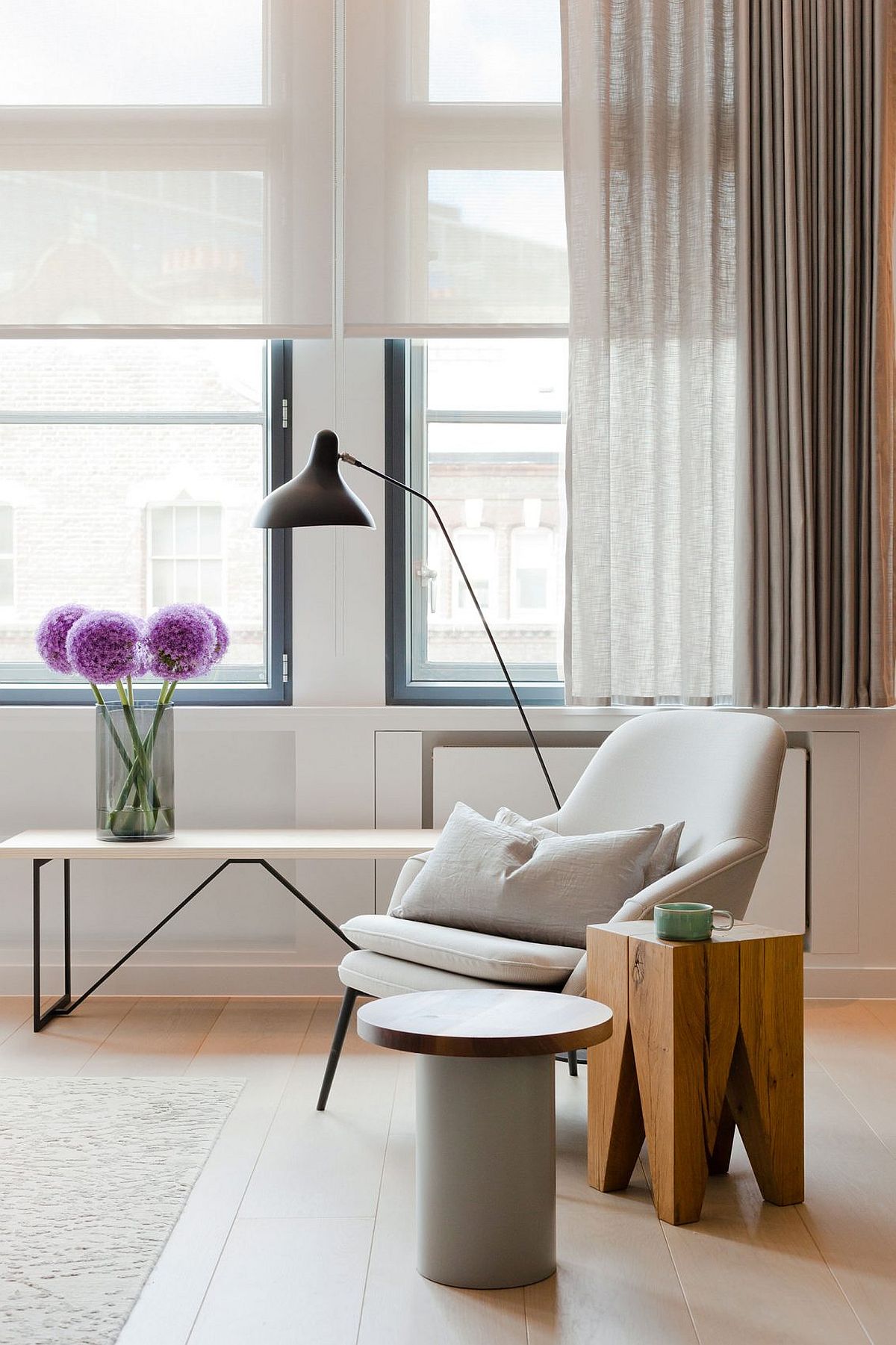 Comfy chair in white and wooden side table for the elegant living room of London penthouse