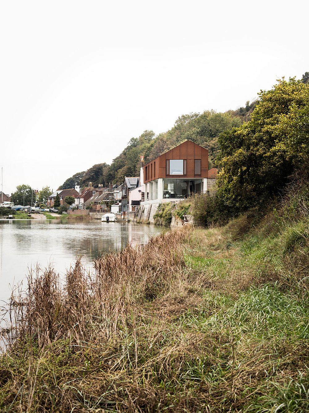 Concrete and cor-ten steel home on the banks of River Ouse