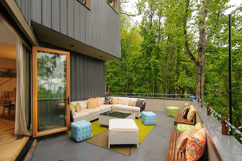 Contemporary deck with luxurious seating, string lighting and a forest view [Design: Smart Builders, Inc]