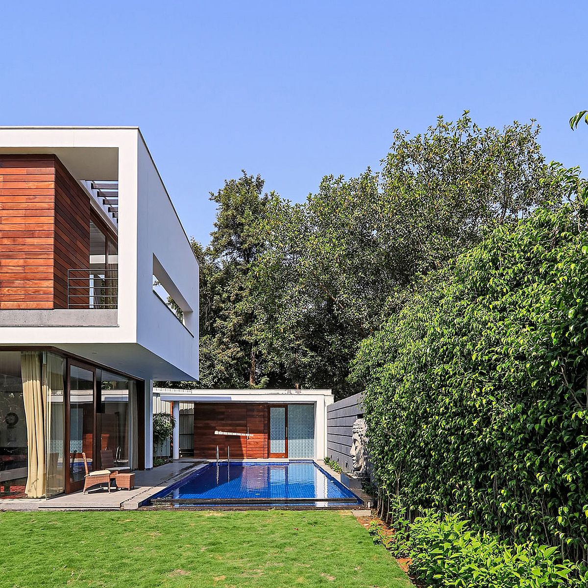 Contemporary pool ahd shaded deck with a small pool house