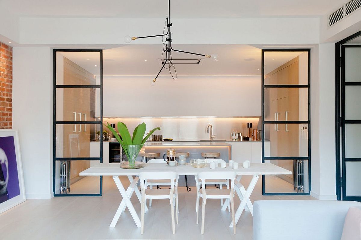 Dining area and kitchen seperated by framed glass partitions with industrial style