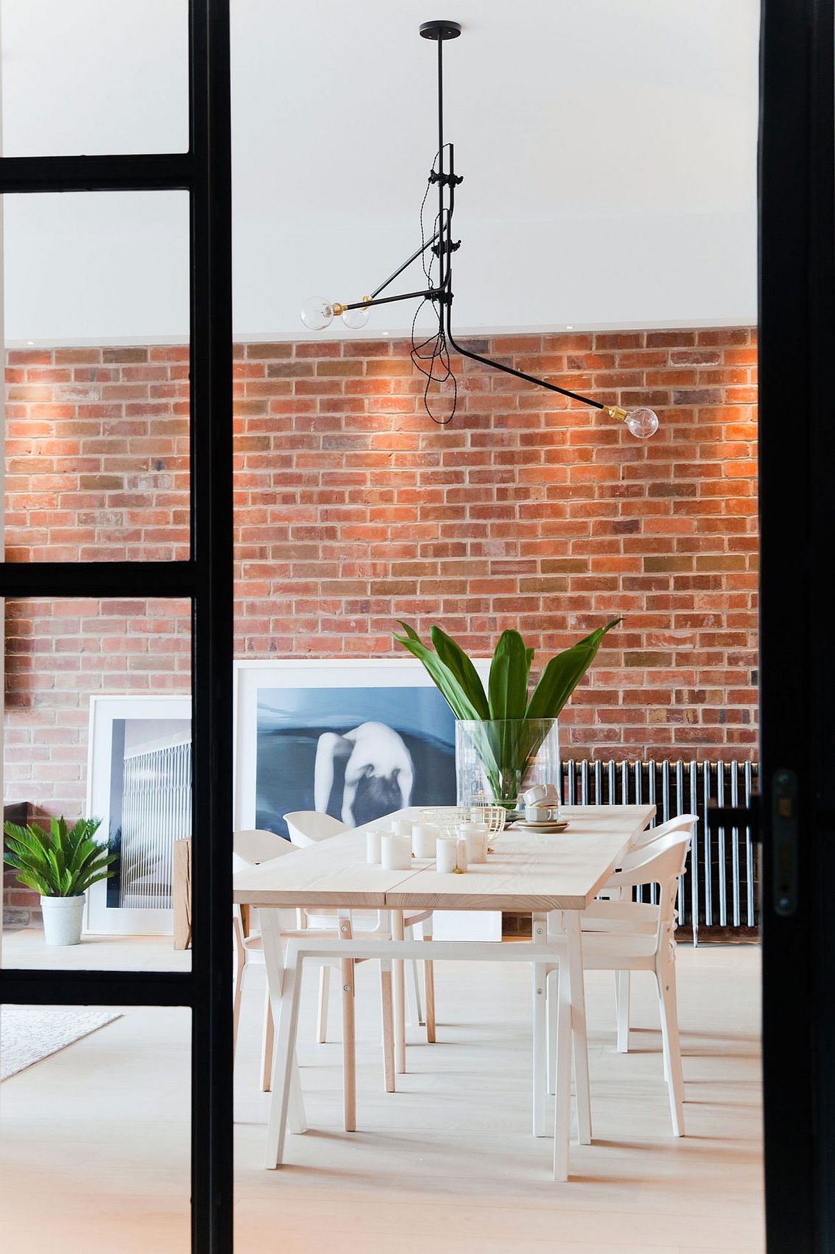 Dining area with industrial style sliding glass doors and brick wall backdrop