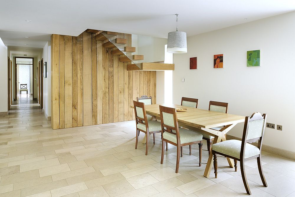 Exquisite reclaimed wood wall with staircase becomes the backdrop in this dining room