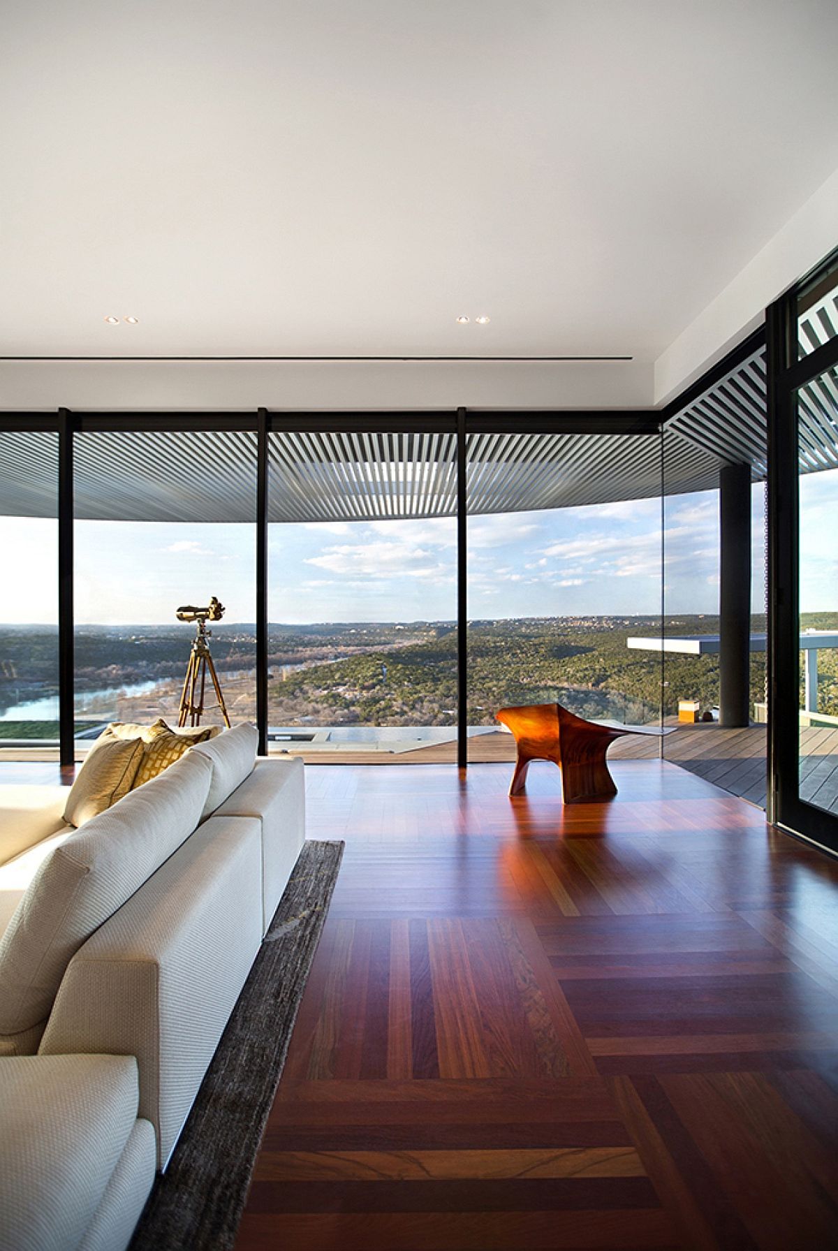 Floor-to-ceiling glass window offer a stunning view of Lake Austin and the rolling hills