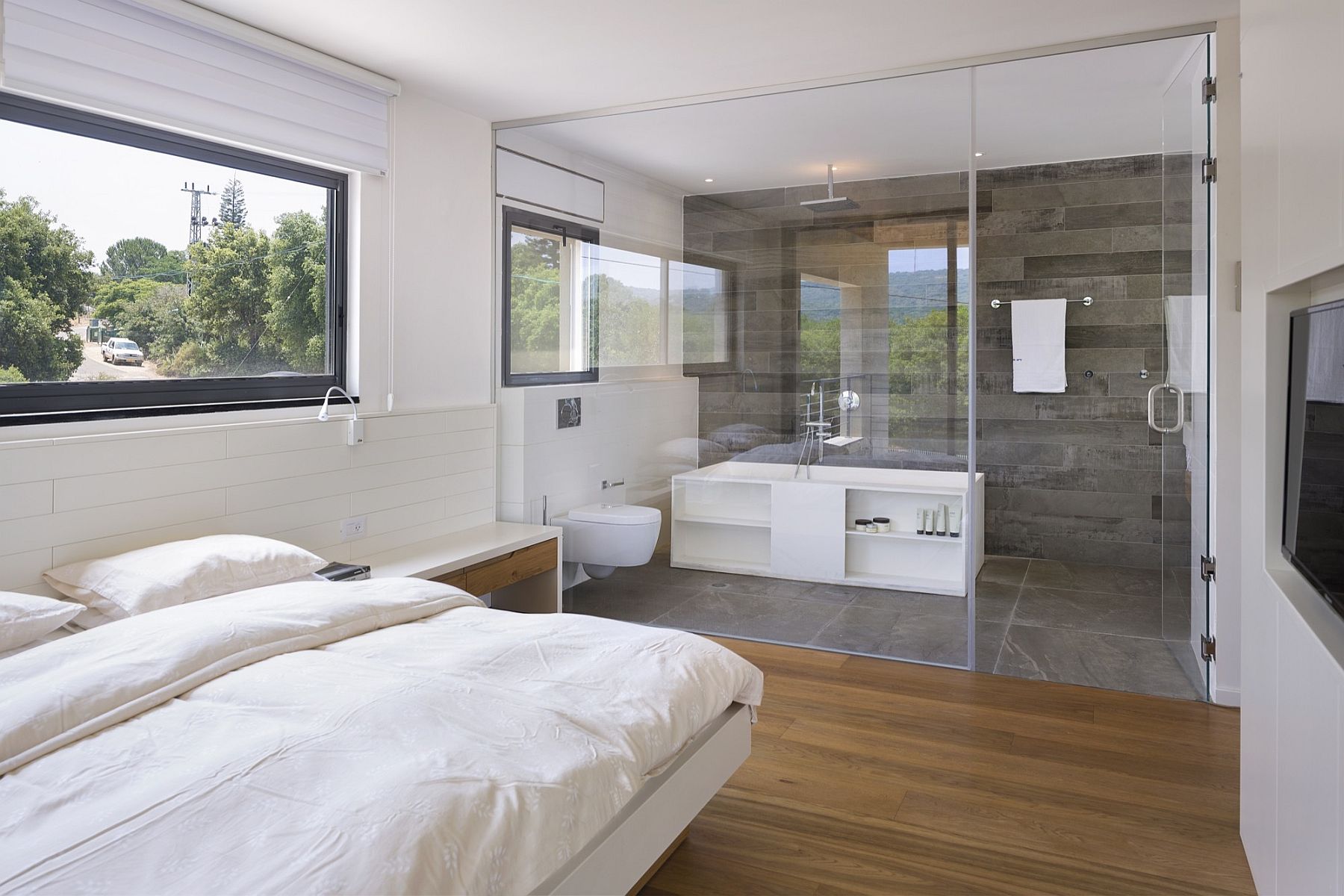 Glass wall seperates the bedroom from the bathroom