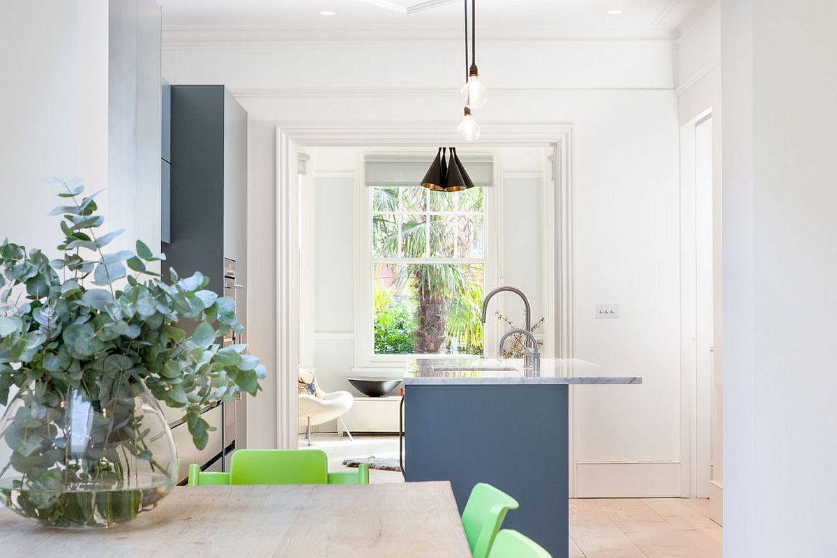 Gorgeous new kitchen with an island in blue offers a view of the living room and the garden