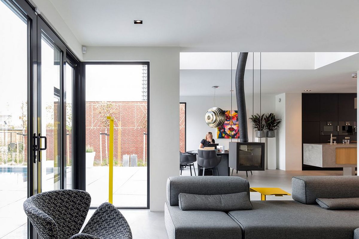 Gorgeous use of dark, framed windows connects the home with the outdoors