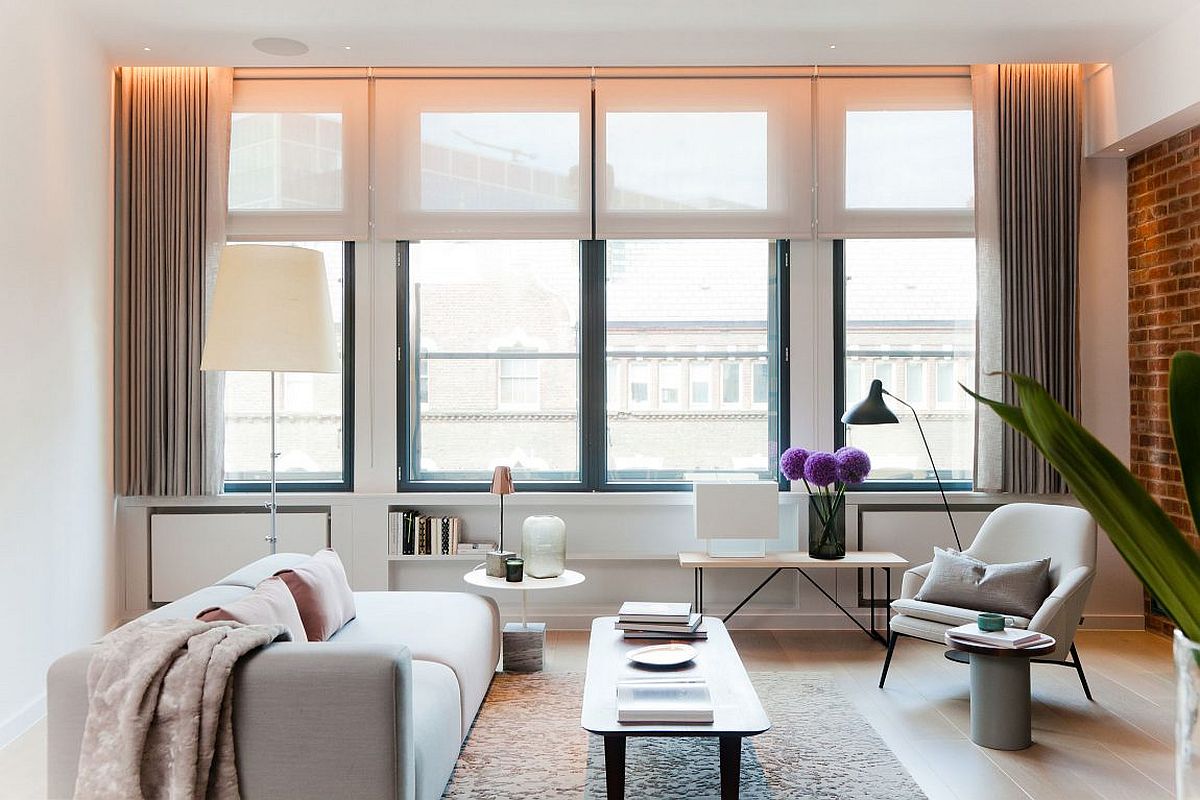 Living room in white with gray drapes, exposed brick wall and NYC loft inspired look