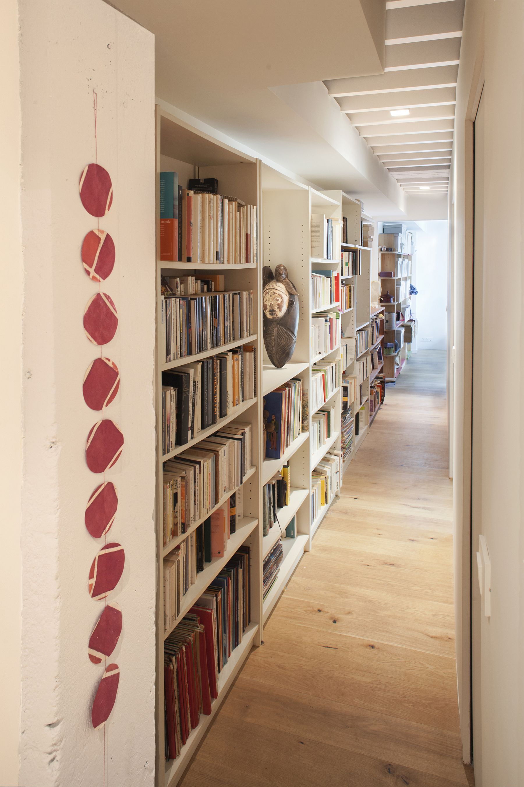 Long corrrridor used to store books in style with a series of wall shelves