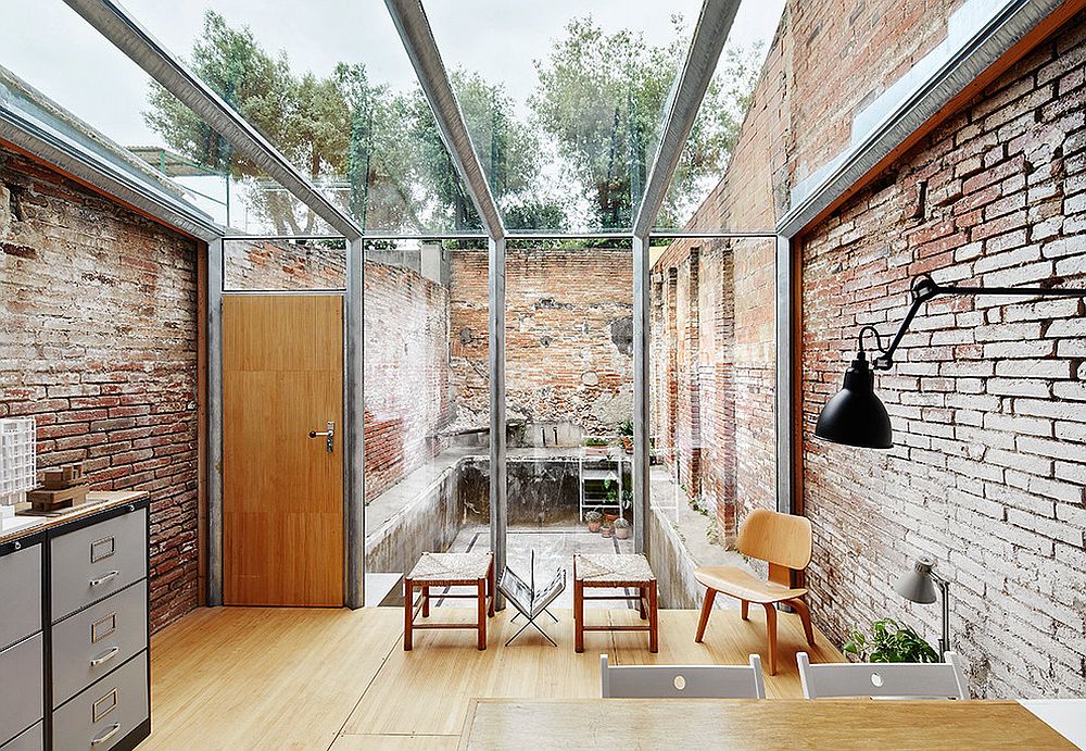 Modern industrial sunroom with lovely brick walls and a glass ceiling [Design: Sauquet Arquitectes i Associats / Photography: José Hevia]