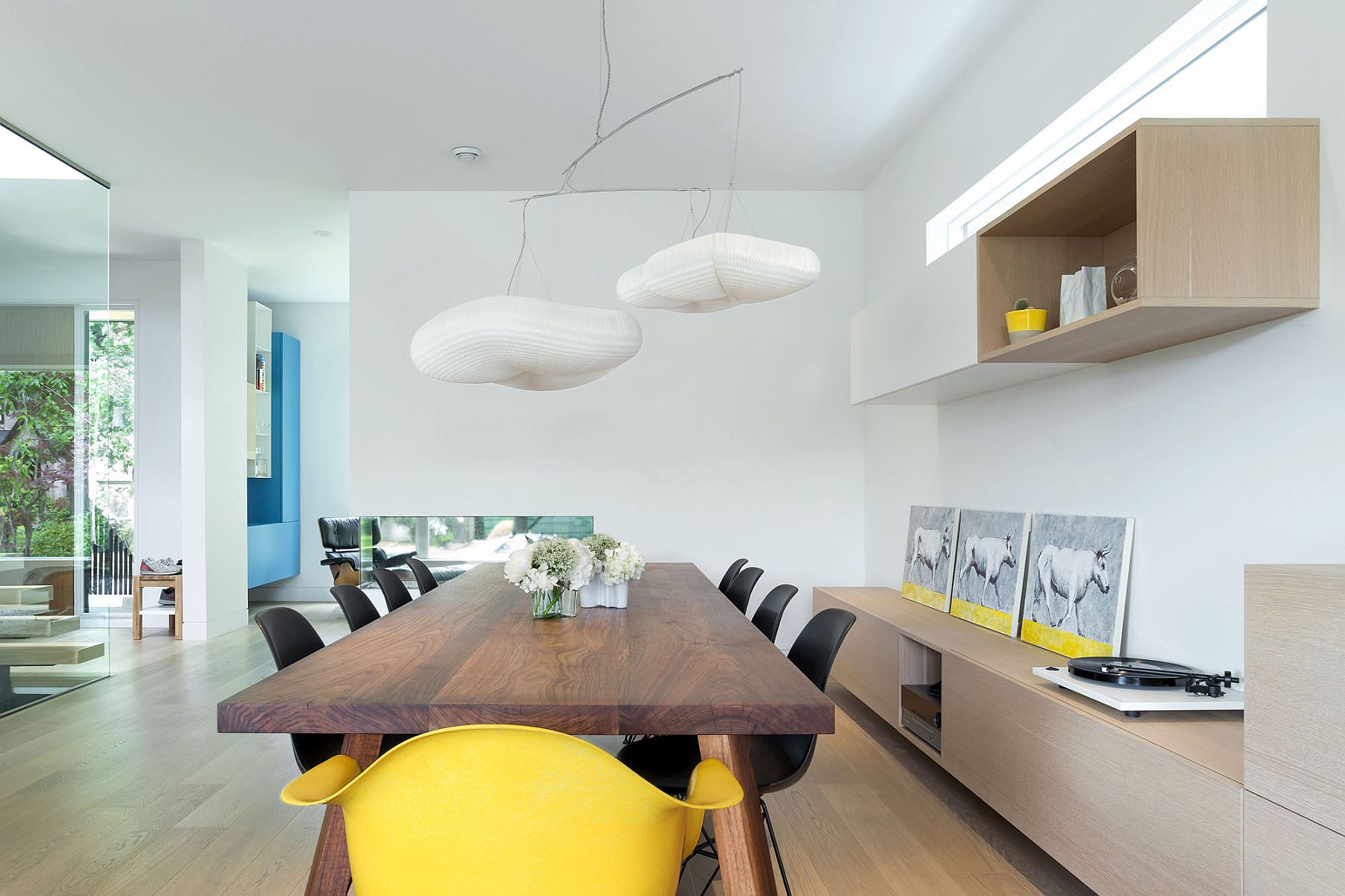 Pendant lights and the yellow chair give the dining space a whimsical appeal