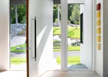 Pivoting-door-in-white-creates-a-dramatic-entry-at-the-Ledgewood-Residence-217x155