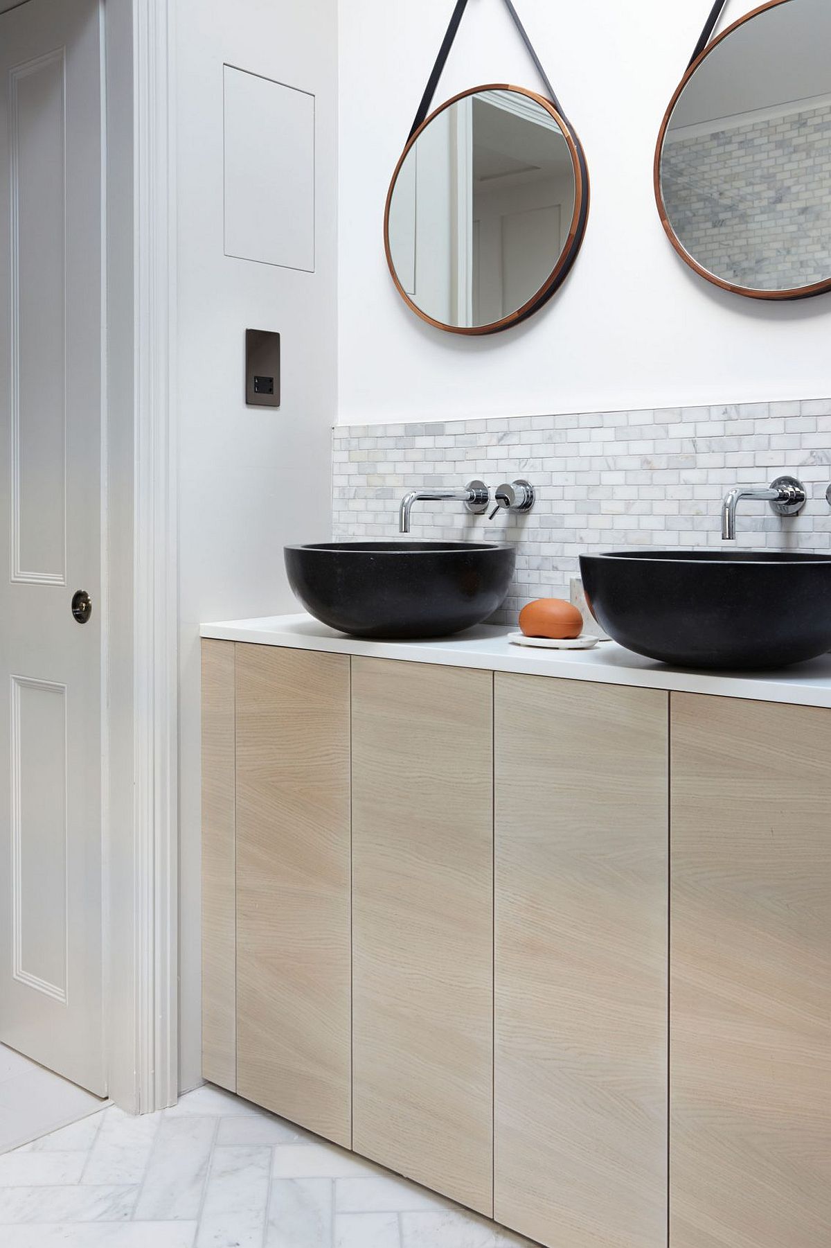 Round mirrors like the ones in this bathroom are a hot trend that also add geo style