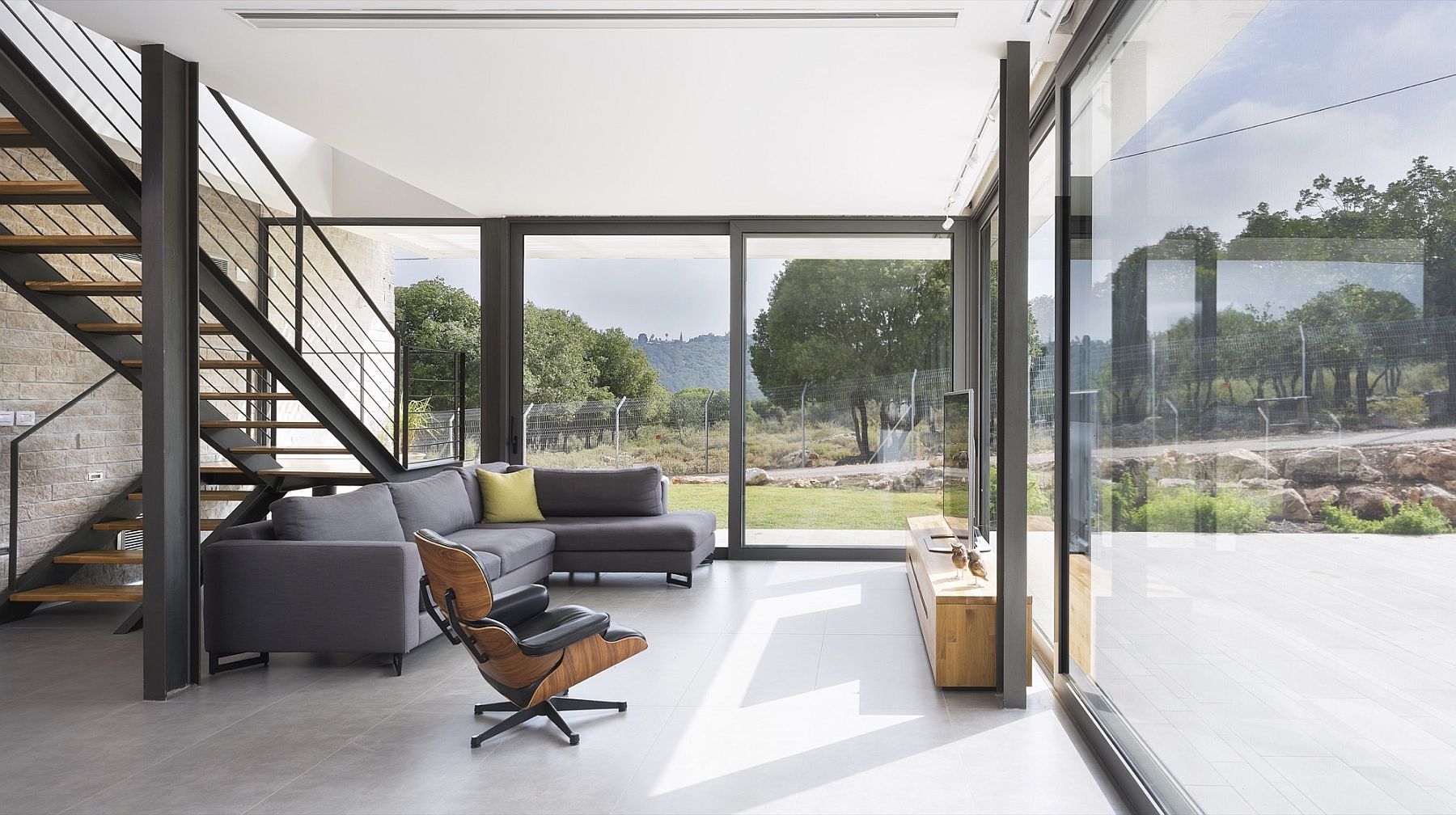 Sliding glazed doors connect the interior with the view outside