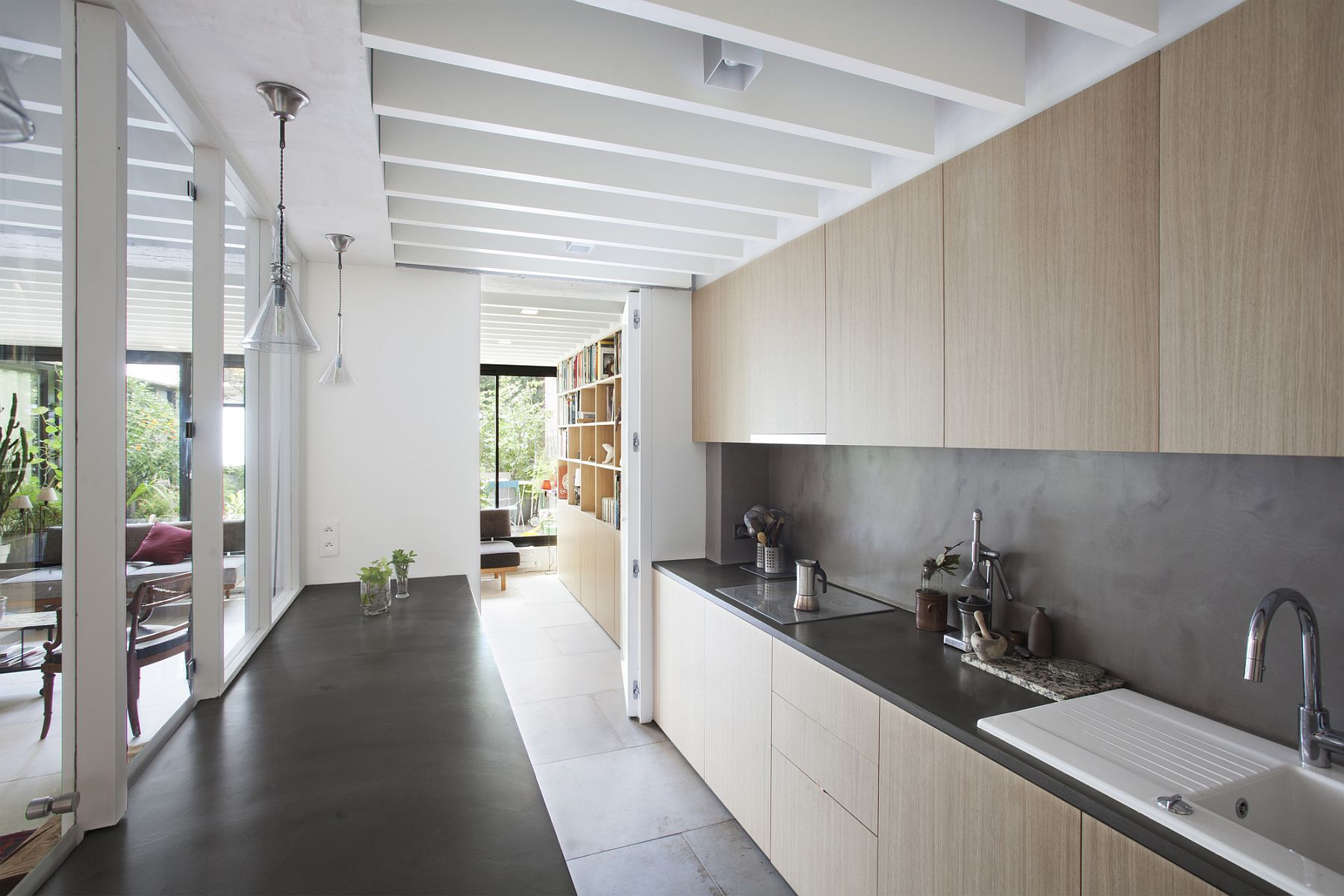 Wooden cabinets and dark kitchen countertops shape the stylish kitchen